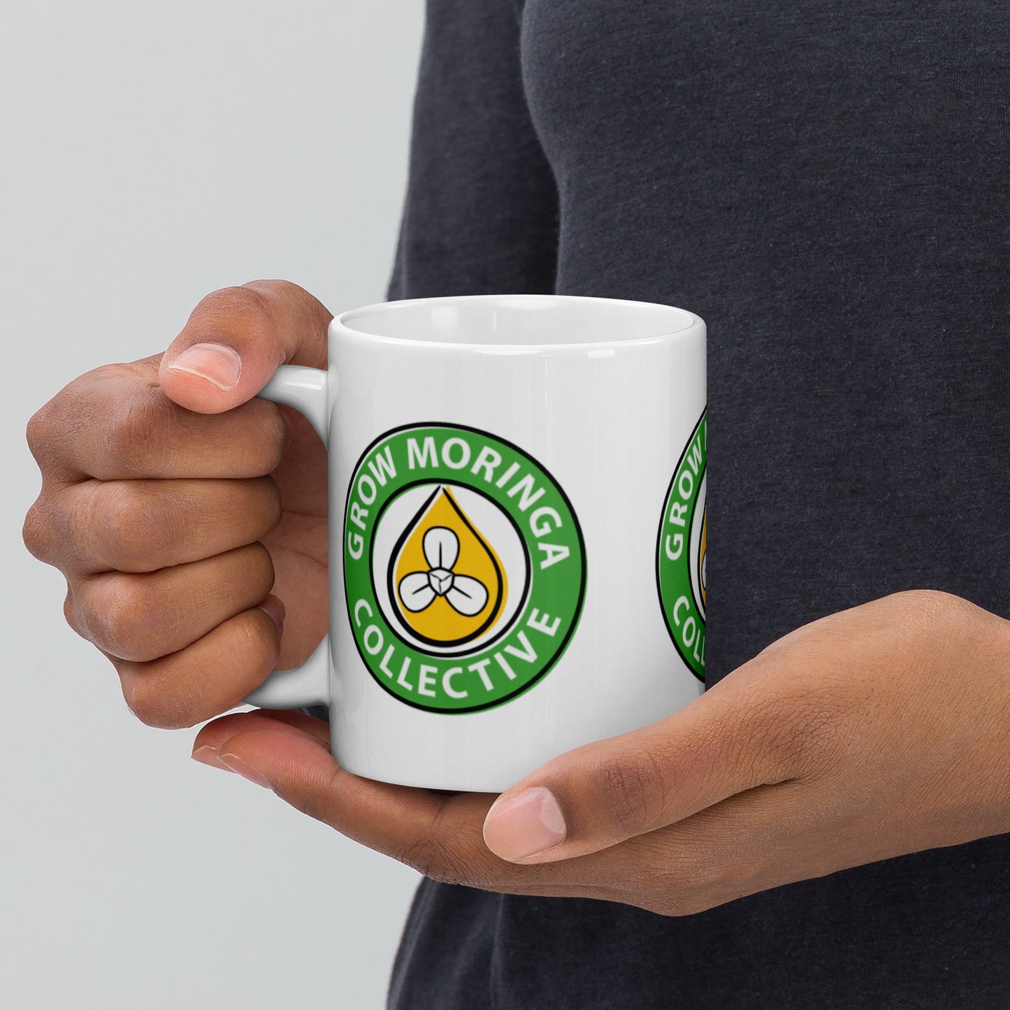 Woman Holding Coffee Mug with Grow Moringa Logo on it.