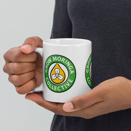 Woman Holding Coffee Mug with Grow Moringa Logo on it.
